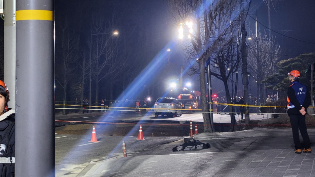 24일 저녁 6시29분쯤 서울 강동구의 한 도로에서 대형 싱크홀(땅 꺼짐) 현상이 발생했다. 소방 관계자들이 도로 통행을 통제하는 모습./사진=김미루 기자