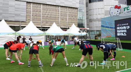  서울 송파구 롯데월드몰 야외광장에서 열린 여자축구 원데이 클래스에서 강원FC 양민혁, 대전하나시티즌 윤도영 선수를 비롯한 참가자들이 준비 운동을 하고 있다./사진=[서울=뉴시스] 김혜진 기자