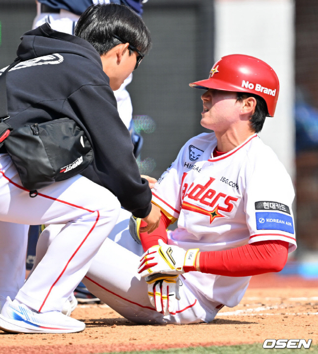 박성한(오른쪽)이 22일 개막전에서 투구에 손목을 맞고 아파하고 있다.