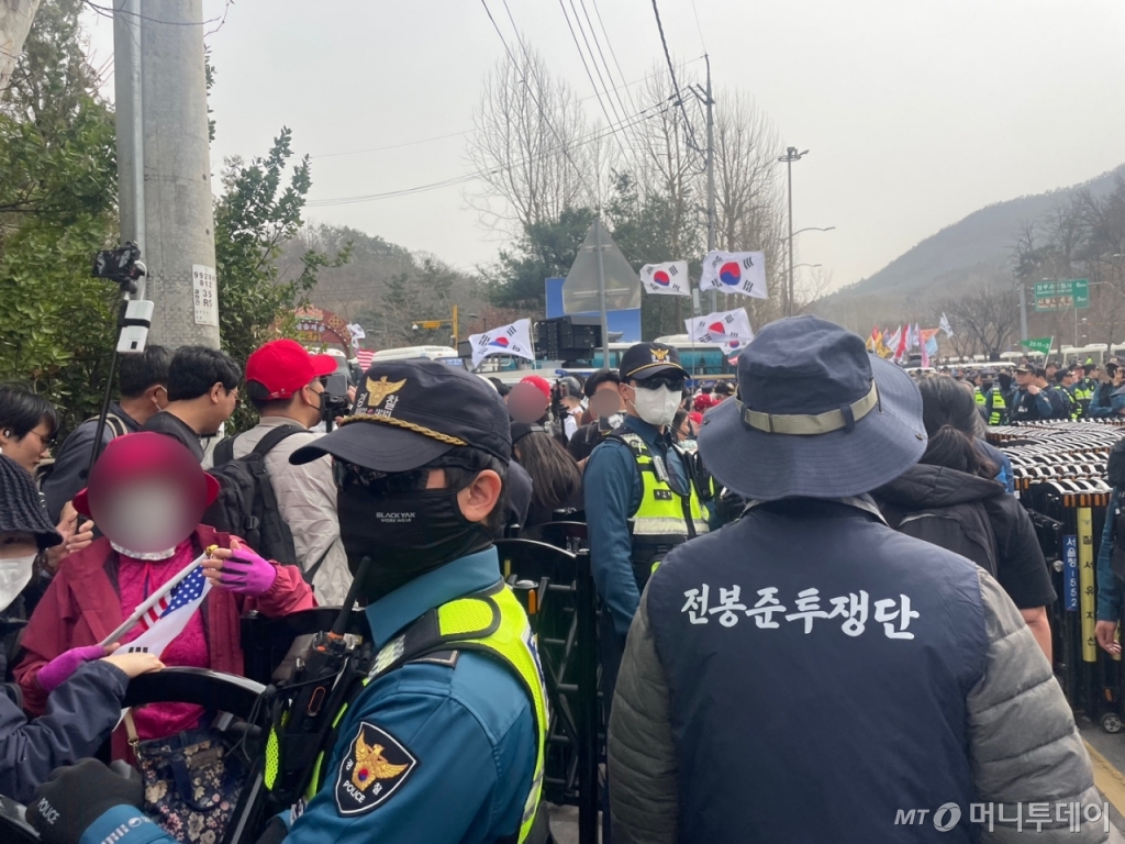 25일 오후 서울 서초구 남태령고개 인근에서 진행된 보수집회 옆으로 전농 소속 농민이 지나가고 있다. /사진=이현수 기자.