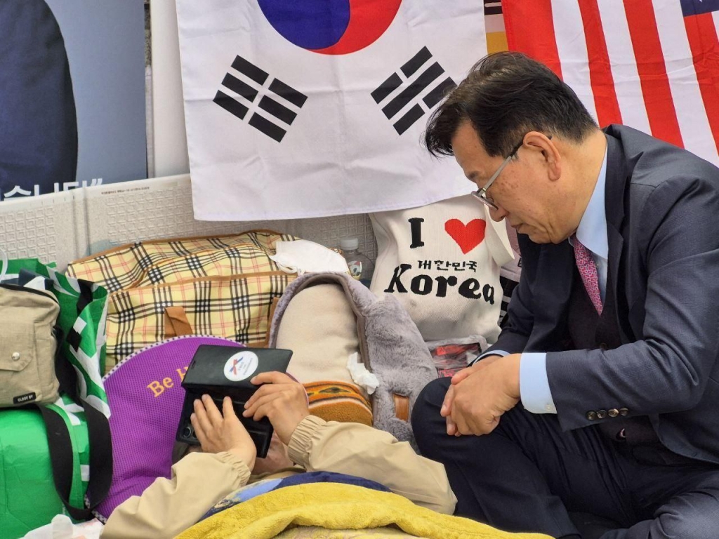 윤석열 대통령 법률대리인단 소속 석동현 변호사(사진 오른쪽)가 25일 오후 헌법재판소 앞에서 단식 중인 지지자 전지영 국가정의실천연합 사무총장을 찾아가 자신의 전화로 윤 대통령과 전 총장을 연결해주고 있다. / 사진=독자제공