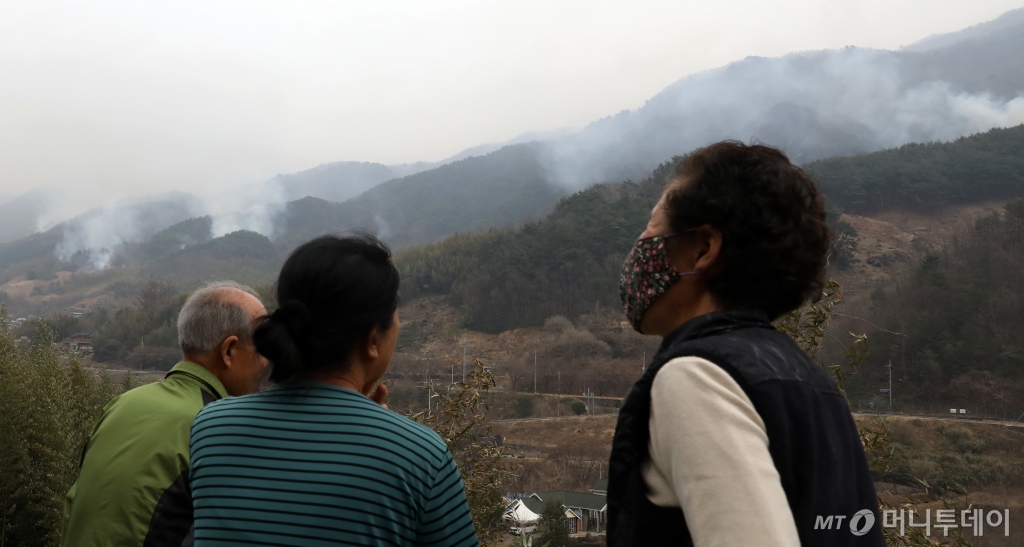 (산청=뉴스1) 윤일지 기자 = 경남 산청·하동 산불 일주일째인 27일 오후 주민들이 지리산과 인접한 산청군 시천면 동당마을 위로 피어오르는 산불 연기를 지켜보고 있다.   산청에는 오후부터 5mm 내외의 적은 비가 예보됐지만 현재 비는 내리지 않고 있다. 2025.3.27/뉴스1  Copyright © 뉴스1. All rights reserved. 무단 전재 및 재배포,  AI학습 이용 금지. /사진=(산청=뉴스1) 윤일지 기자