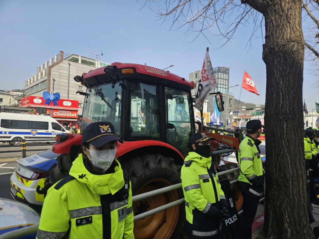 지난 26일 서울 종로구 경복궁 2번출구 근처에서 전국농민회총연맹(전농)측이 경복궁에 무단으로 세운 트랙터를 경찰이 견인하던 중 탄핵 찬성 집회 참가자들이 몰려들어 대치 상황에 놓여 있다. 결국 트랙터는 갓길에 세워졌다./사진=박상혁 기자.