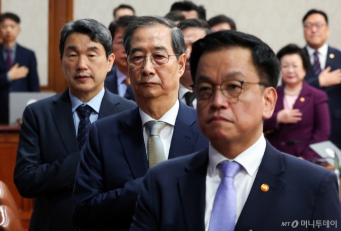 [서울=뉴시스] 최진석 기자 = 한덕수 대통령 권한대행 국무총리가 1일 정부서울청사에서 열린 국무회의에서 국기에 경례하고 있다. 왼쪽부터 이주호 사회부총리 겸 교육부 장관, 한 대통령 권한대행, 최상목 경제부총리 겸 기획재정부 장관. 2025.04.01. /사진=최진석