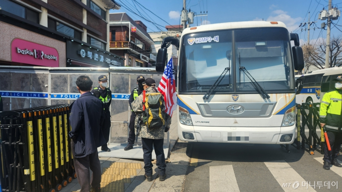 3일 오후 성조기를 가방에 꽂은 남성이 헌재 앞 인도를 지나가겠다고 했지만 가로막혔다. /사진=김미루 기자.
