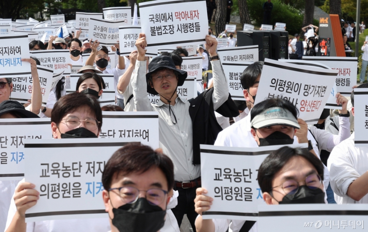 [서울=뉴시스] 추상철 기자 = 3일 오후 서울 용산구 대통령실 앞에서 열린 '의학교육평가원 무력화 저지를 위한 전국의과대학 교수 결의대회'에서 참가자들이 구호를 외치고 있다. 2024.10.03. scchoo@newsis.com /사진=추상철