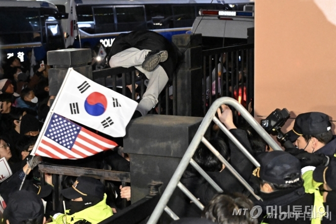 (서울=뉴스1) 민경석 기자 = 내란 우두머리 혐의로 체포된 윤석열 대통령의 영장실질심사가 열린 18일 오후 서울 마포구 서울서부지방법원에서 윤 대통령 지지자들이 법원 담장을 넘고 있다.(공동취재) 2025.1.19/뉴스1  Copyright © 뉴스1. All rights reserved. 무단 전재 및 재배포,  AI학습 이용 금지. /사진=(서울=뉴스1) 민경석 기자