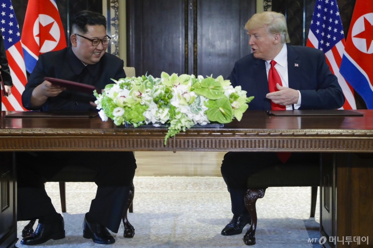 2018년 6월 당시 도널드 트럼프 미국 대통령과 김정은 북한 국무위원장이 싱가포르 센토사 섬 내 카펠라 호텔에서 합의문에 서명한 후 웃고 있는 모습. / 사진=머니투데이DB