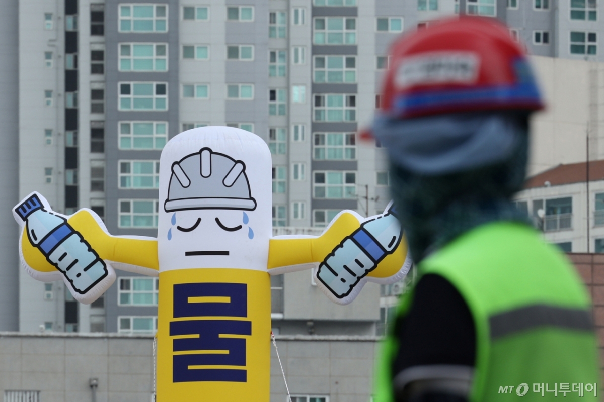 서울의 한 공사 현장에서 관계자들이 땡볕 아래 근무를 하고 있다. 뒤로 물 섭취 안내 풍선이 보인다./사진=(서울=뉴스1) 신웅수 기자