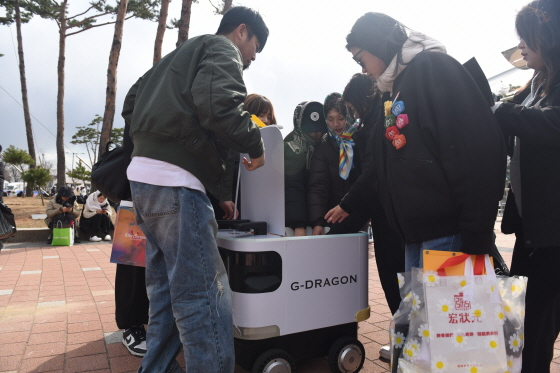 자율주행 로봇 로보티즈가 지드래곤 콘서트 야외에서 팬들에게 간식을 배달하고 있다/사진제공=갤럭시코퍼레이션