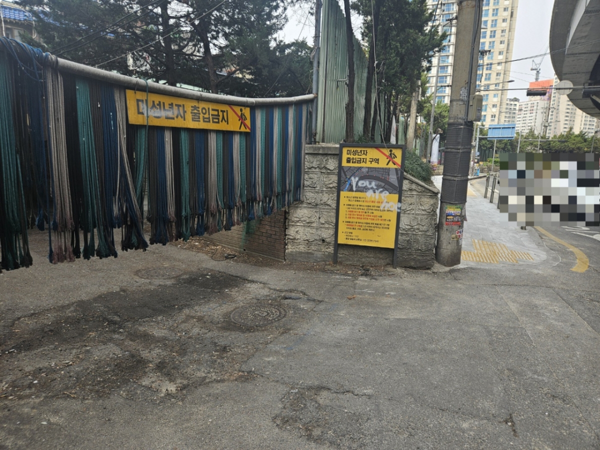 지난 17일 오후 서울 성북구 신웍곡 1구역 성매매 집결지 '미아리 텍사스' 앞으로 차들이 지나가고 있다. 사진 뒷편엔 새로 지어진 아파트 모습이 보인다./사진=박상혁 기자.