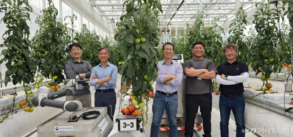 국립농업과학원 이충근 농업로봇과장(사진 왼쪽 두번째)이 22일 우리 기술로 직접 개발한 모니터링 로봇, 운반 로봇 앞에서 홍영기 농업연구관(왼쪽 세번째), 김국환 농업연구관(왼쪽 다섯번째), 김경철 농업연구사(왼쪽 첫번째) 등 연구진과 함께 활짝 웃고 있다. /사진=정혁수