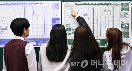 [수원=뉴시스] 김종택 기자 = 2025학년도 대학수학능력시험 성적표가 배부된 6일 경기도 수원시 효원고등학교 3학년 교실에서 수험생들이 전국대학 지원 참고표를 살펴보고 있다. 2024.12.06. jtk@newsis.com /사진=김종택