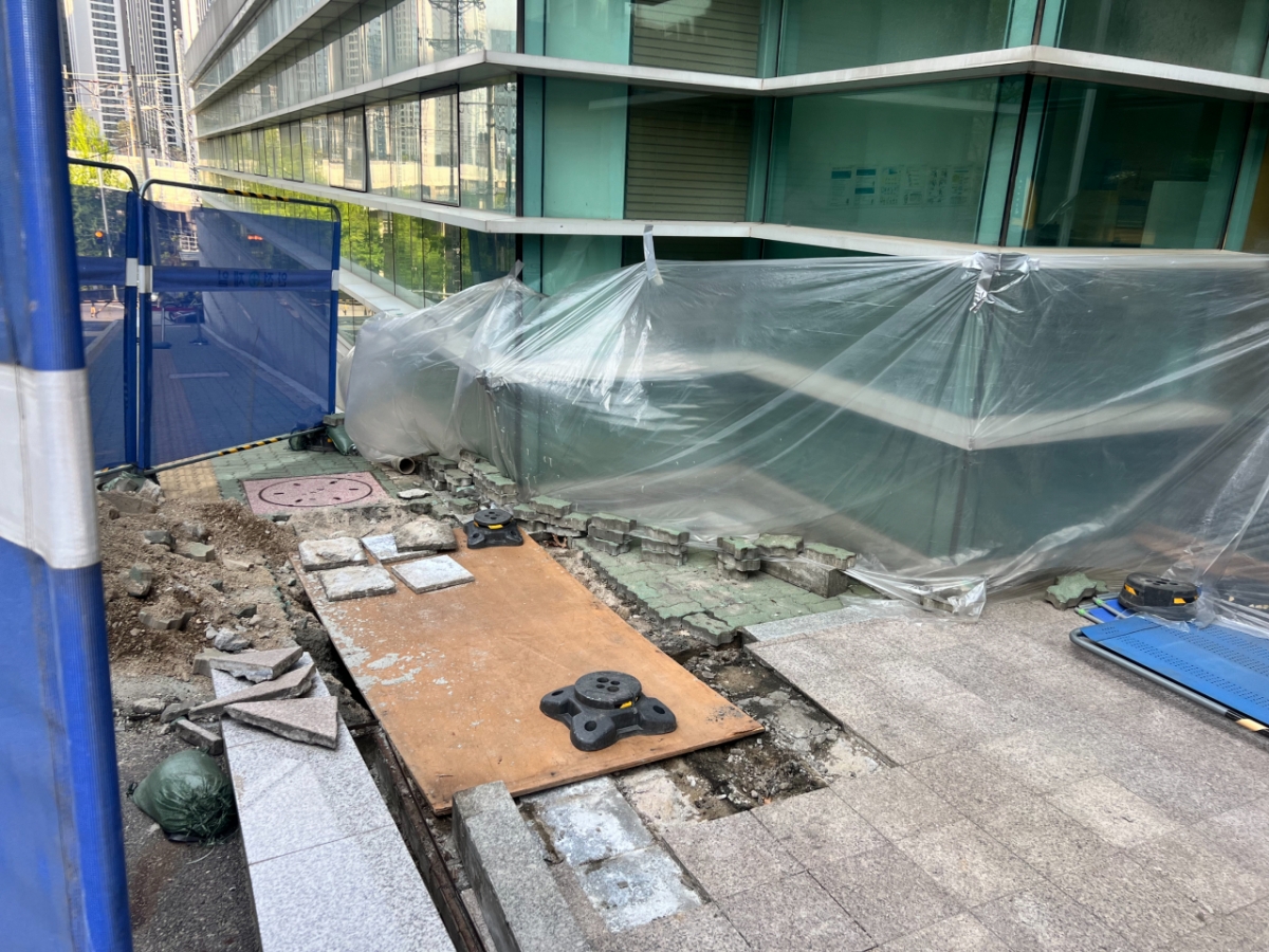 기자가 25일 오전 건물 앞을 찾았을 때는 싱크홀과 지반 침하 지역을 주변으로 안전 펜스가 설치된 상태였다. 싱크홀 주변 보도블록을 걷어낸 뒤 널빤지로 구멍을 덮어놨다. /사진=민수정 기자.