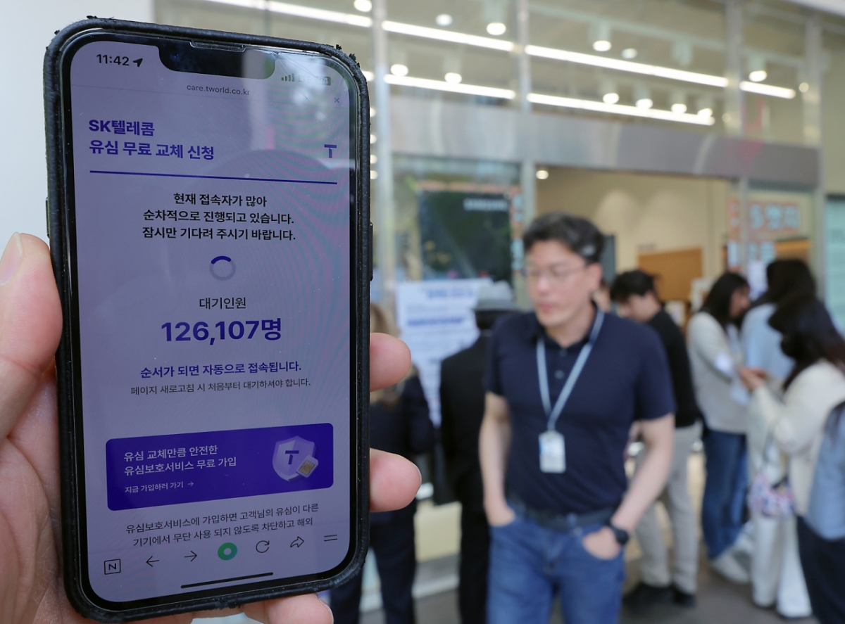 해킹 공격으로 가입자 유심 정보가 탈취된 SK텔레콤이 가입자 유심 무상 교체를 시작한 28일 오전 서울 종로구 T월드 매장 앞에서 직원들의 안내를 받아 온라인 예약을 하고 있다. /사진=뉴스1