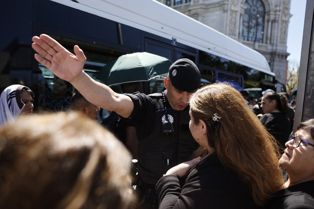 28일(현지시간) 스페인 경찰이 안전사고를 막기 위해 버스를 타기 위해 몰려드는 사람들을 제지하고 있다./AFPBBNews=뉴스1