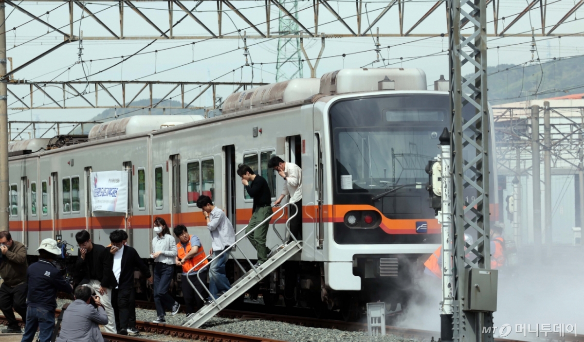 [부산=뉴시스] 하경민 기자 = 사진은 기사와 관련없음. 2025년 충무훈련의 하나로 '도시철도 피해복구 종합 실제훈련'이 열린 23일 부산 금정구 도시철도 1호선 노포차량정비창에서 테러를 당한 도시철도 승객들이 대피하고 있다.   전시 적 공격으로 인한 도시철도 시설피해 발생에 대비한 민·관·군·경·소방 합동훈련에는 53사단 부산여단과 부산교통공사, 금정구청, 금정소방서, 보건소, 부산항만공사, 금정결찰서 등 7개 기관 200여 명이 참가했다. 2025.04.23. yulnetphoto@newsis.com /사진=하경민