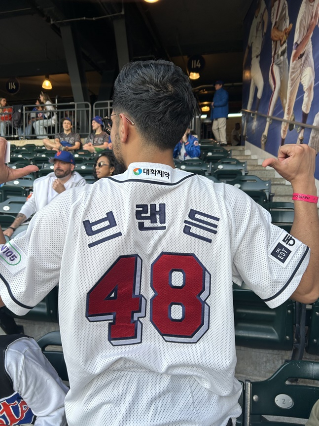 브랜든 와델의 친구인 트레이 마르티네스가 두산 시절 브랜든의 유니폼을 입고 응원하고 있다. /사진=존 모로시 SNS 갈무리