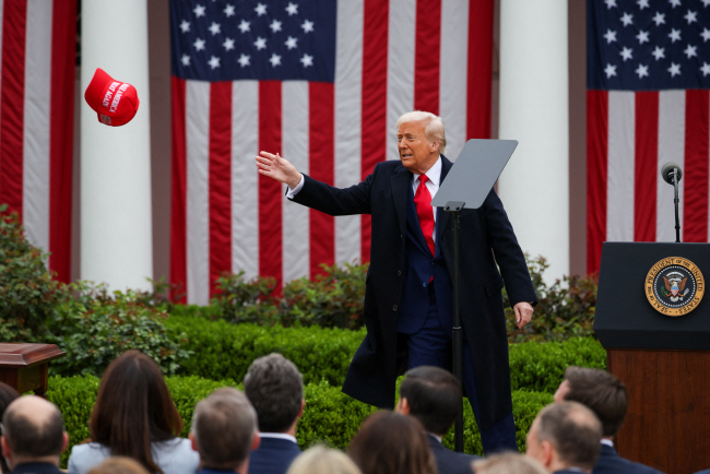 도널드 트럼프 미국 대통령이 지난 4월3일 상호관세를 발표하면서 '미국을 다시 위대하게'(Make America Great Again·MAGA)라는 문구가 써진 모자를 청중들에게 던지고 있다. /로이터=뉴스1