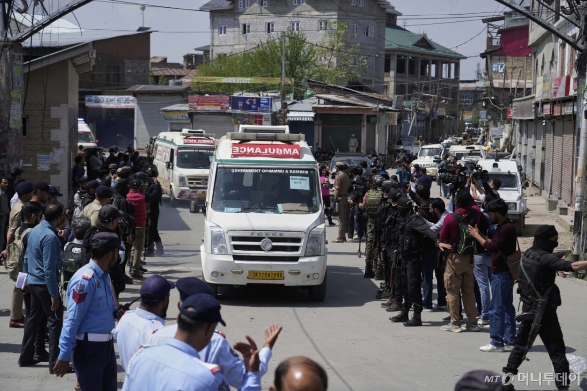 Police guard as ambulances carry bodies of tourists, in Srinagar, Indian controlled Kashmir, Wednesday, April. 23, 2025. (AP Photo/Mukhtar Khan)