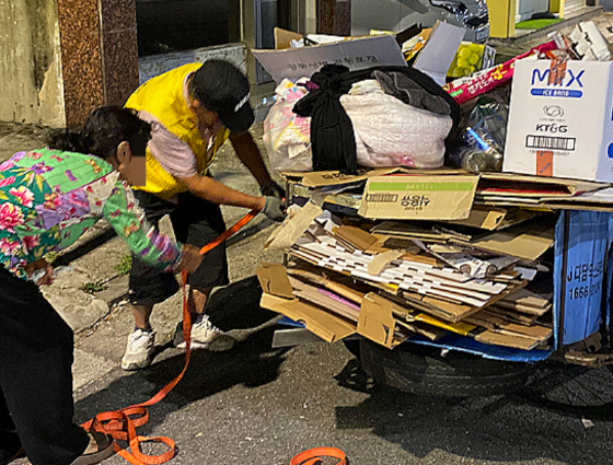 지난해 새벽 만난 폐지 수집 어르신들. 그 고단함을 서로가 가장 잘 알기에, 힘을 합쳐 정리를 돕고 있었다./사진=남형도 기자