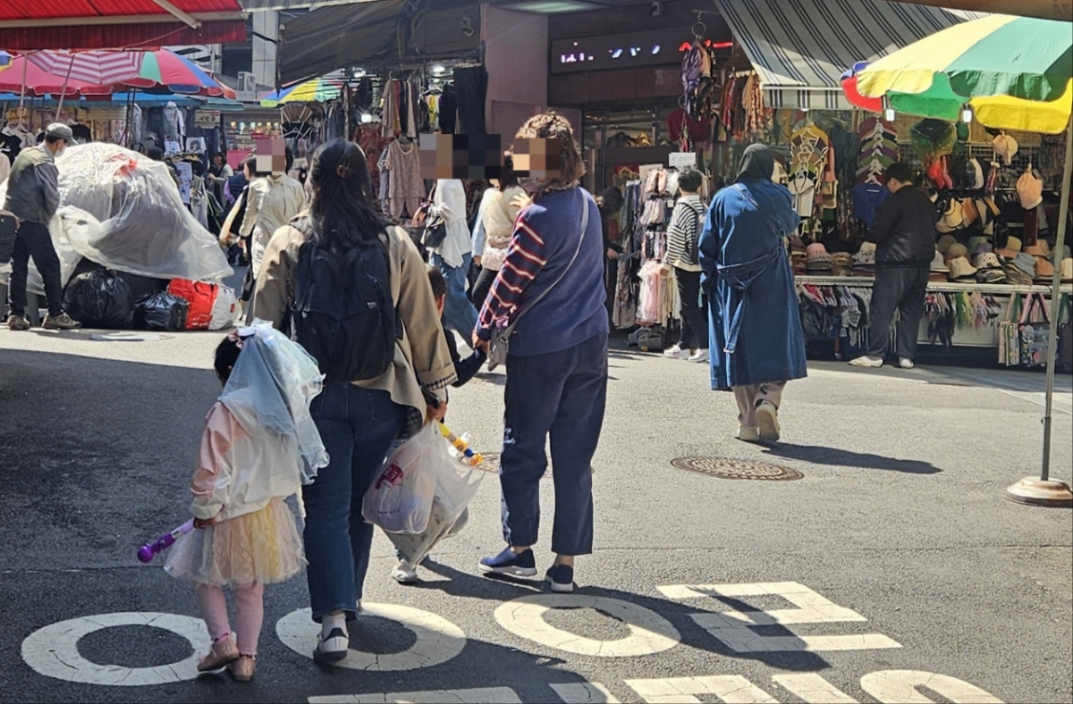 7일 오전 서울 중구 남대문시장에 한 어린아이가 엄마 손을 잡고 걸어가고 있다./사진=박상혁 기자.