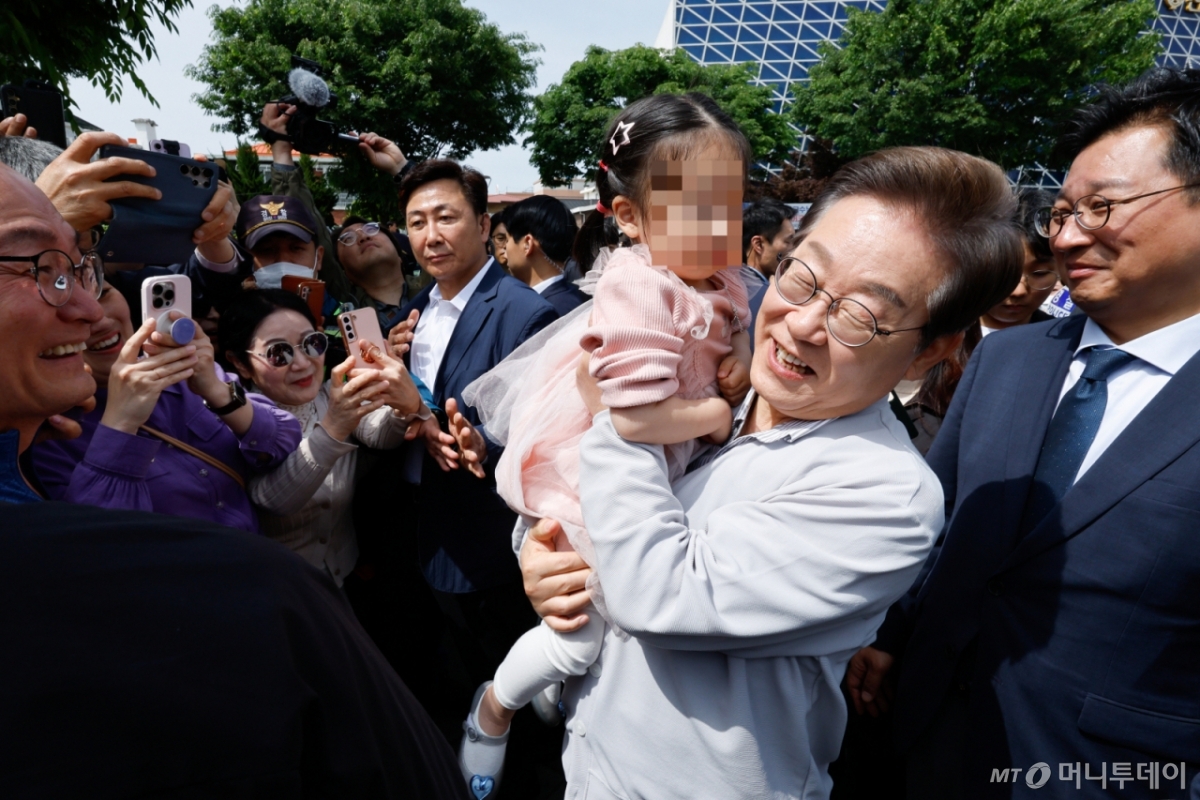 (전주=뉴스1) 안은나 기자 = 이재명 더불어민주당 대통령 후보가 2차 골목골목 경청투어 마지막 날인 7일 오후 전북 전주시 풍남문 앞에서 한 어린이를 안아들고 있다. 2025.5.7/뉴스1 Copyright © 뉴스1. All rights reserved. 무단 전재 및 재배포, AI학습 이용 금지. /사진=(전주=뉴스1) 안은나 기자