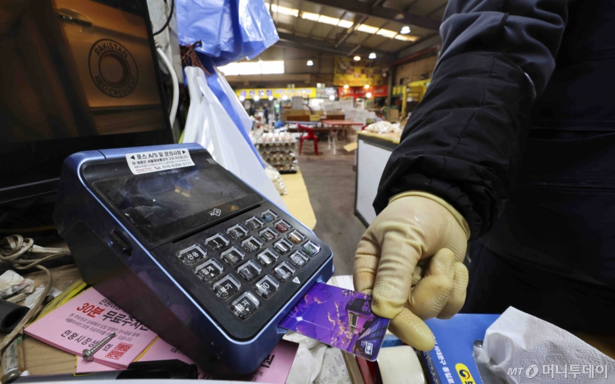 [서울=뉴시스] 김근수 기자 = 14일 서울 시내의 한 점포에서 점주가 신용카드로 물건을 결제하고 있다.   금융위원회는 '2025년 상반기 영세·중소가맹점 선정 결과’를 통해 영세·중소신용카드가맹점들의 신용·체크카드 수수료 부담이 기존보다 0.05∼0.10%p 낮아진다.  올해 상반기 신용카드가맹점 305만9000개, 결제대행업체 하위가맹점 181만5000개, 택시사업자 16만6000개에 우대수수료율을 적용키로 했다고 밝혔다. 2025.02.14. ks@newsis.com /사진=김근수