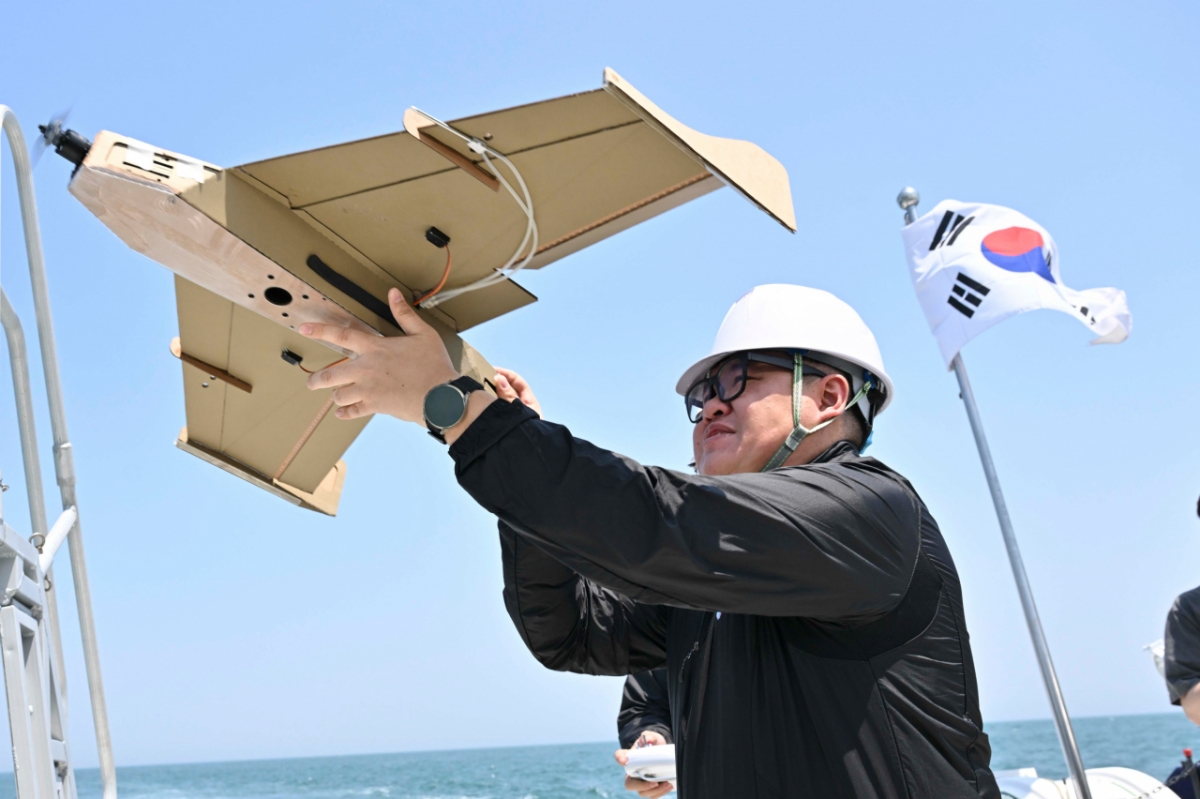 민간 드론업체 관계자가 자폭용 골판지 드론을 손으로 날려보내는 모습. / 사진=해군