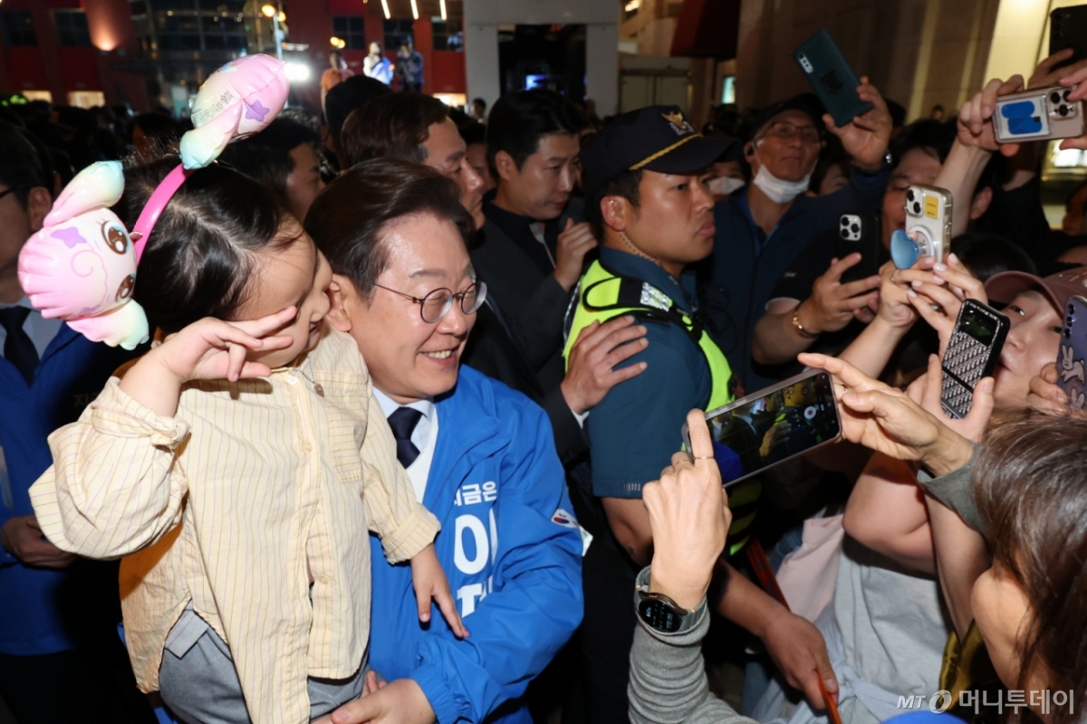 (울산=뉴스1) 안은나 기자 = 이재명 더불어민주당 대통령 후보가 대표적 험지인 대구·경북(TK) 지역 유세에 돌입한 13일 오후 울산 남구 롯데백화점 광장에서 유세 후 어린이와 기념촬영을 하고 있다.2025.5.13/뉴스1 2025.5.13/뉴스1 Copyright © 뉴스1. All rights reserved. 무단 전재 및 재배포, AI학습 이용 금지. /사진=(울산=뉴스1) 안은나 기자