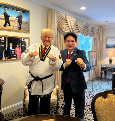 도널드 트럼프 미국 대통령이 2021년 11월19일(현지시간) 미국 플로리다주 팜비치의 마러라고 리조트에서 이동섭 국기원장으로부터 태권도 명예 9단증을 받은 뒤 태권도복을 입고 포즈를 취하고 있다. / 사진=국기원
