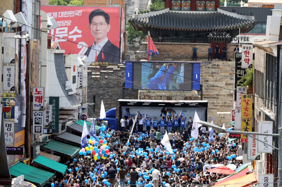 (수원=뉴스1) 안은나 기자 = 이재명 더불어민주당 대통령 후보가 26일 오후 경기 수원시 팔달문 영동시장 입구를 찾아 집중 유세를 펼치는 가운데 무대 인근에 김문수 국민의힘 후보의 대형 현수막이 걸려 있다. (공동취재) 2025.5.26/뉴스1  Copyright © 뉴스1. All rights reserved. 무단 전재 및 재배포,  AI학습 이용 금지. /사진=(수원=뉴스1) 안은나 기자