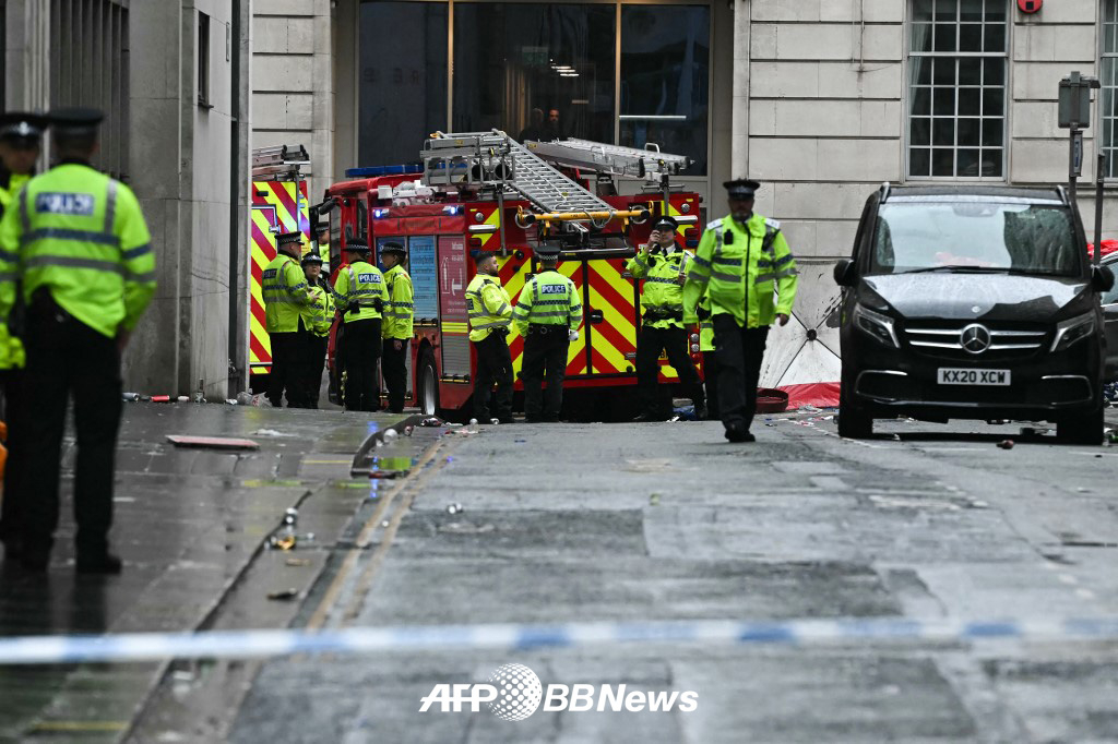 26일(현지시간) 영국 리버풀 워터 스트리트에서 진행된 리버풀FC의 2024~2025 잉글랜드 프리미어리그 우승 퍼레이드 도중 발생한 차량 돌진 사고 이후 현장을 수습하고 있는 리버풀 경찰. /AFPBBNews=뉴스1