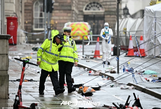 영국 현지 경찰이 지난 26일(현지시간) 영국 리버풀 워터 스트리트에서 진행된 리버풀FC의 2024~2025 잉글랜드 프리미어리그 우승 퍼레이드 도중 발생한 차량 돌진 사고 이후 현장을 조사하고 있다. /AFPBBNews=뉴스1
