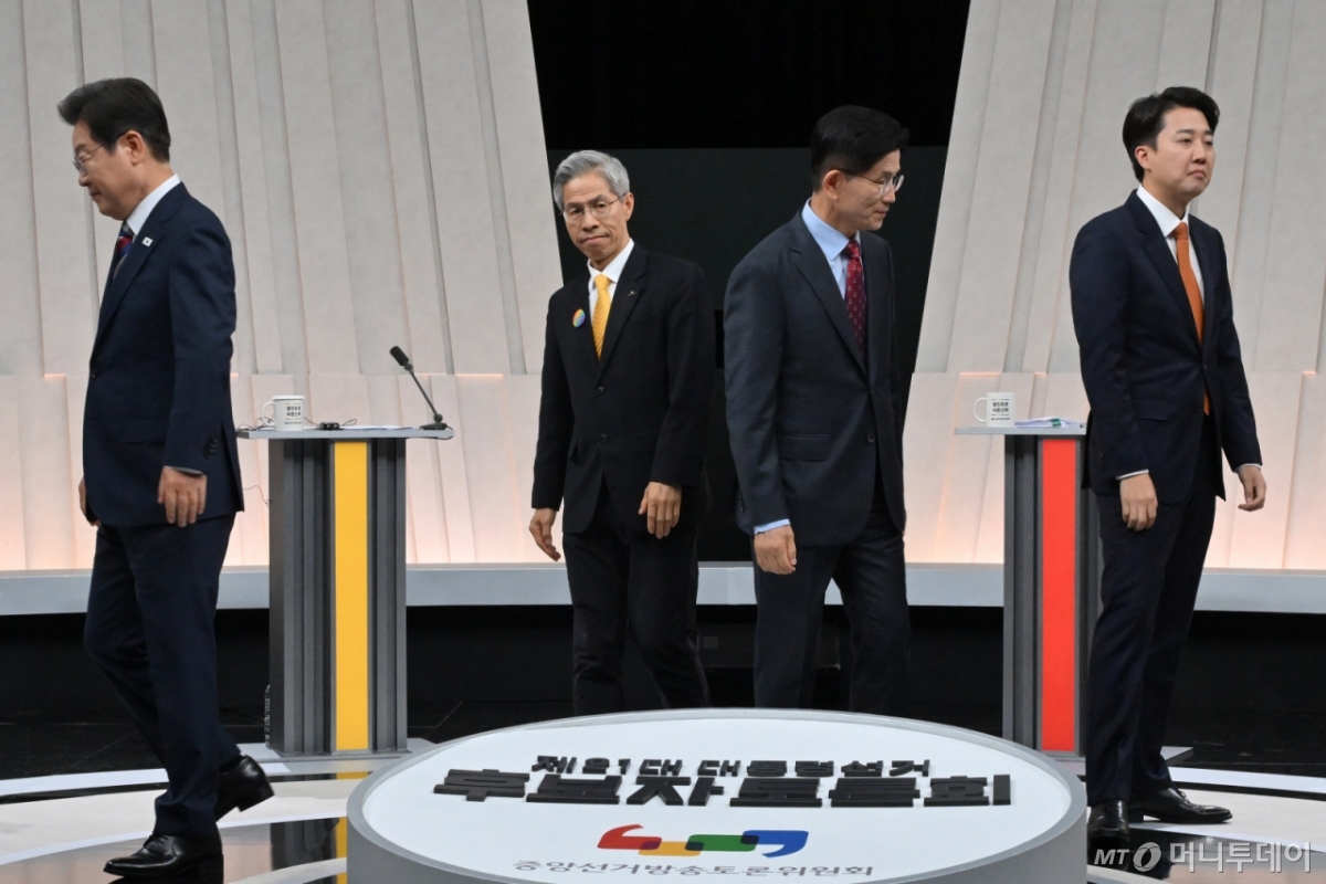 [서울=뉴시스] 국회사진기자단 = 27일 오후 서울 마포구 상암동 MBC 스튜디오에서 열린 중앙선거방송토론위원회 주관 제21대 대통령선거 3차 후보자토론회 시작에 앞서 각 정당 대선후보들이 기념촬영을 마친 뒤 자리로 돌아가고 있다. 왼쪽부터 이재명 더불어민주당, 권영국 민주노동당, 김문수 국민의힘, 이준석 개혁신당 대선후보. 2025.05.27. photo@newsis.com /사진=