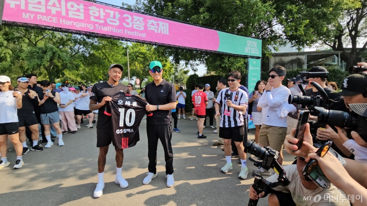 오세훈 서울시장이 1일 오전 서울 광진구 뚝섬한강공원에서 열린 쉬엄쉬엄 한강 3종 축제 10km 달리기 출발점에서 FC서울 소속 축구선수 제시 린가드에게 유니폼을 선물받은 뒤 기념촬영하고 있다./사진=정세진 기자 