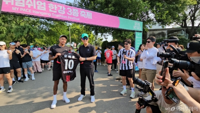 오세훈 서울시장이 1일 오전 서울 광진구 뚝섬한강공원에서 열린 쉬엄쉬엄 한강 3종 축제 10km 달리기 출발점에서 FC서울 소속 축구선수 제시 린가드에게 유니폼을 선물받은 뒤 기념촬영하고 있다./사진=정세진 기자 