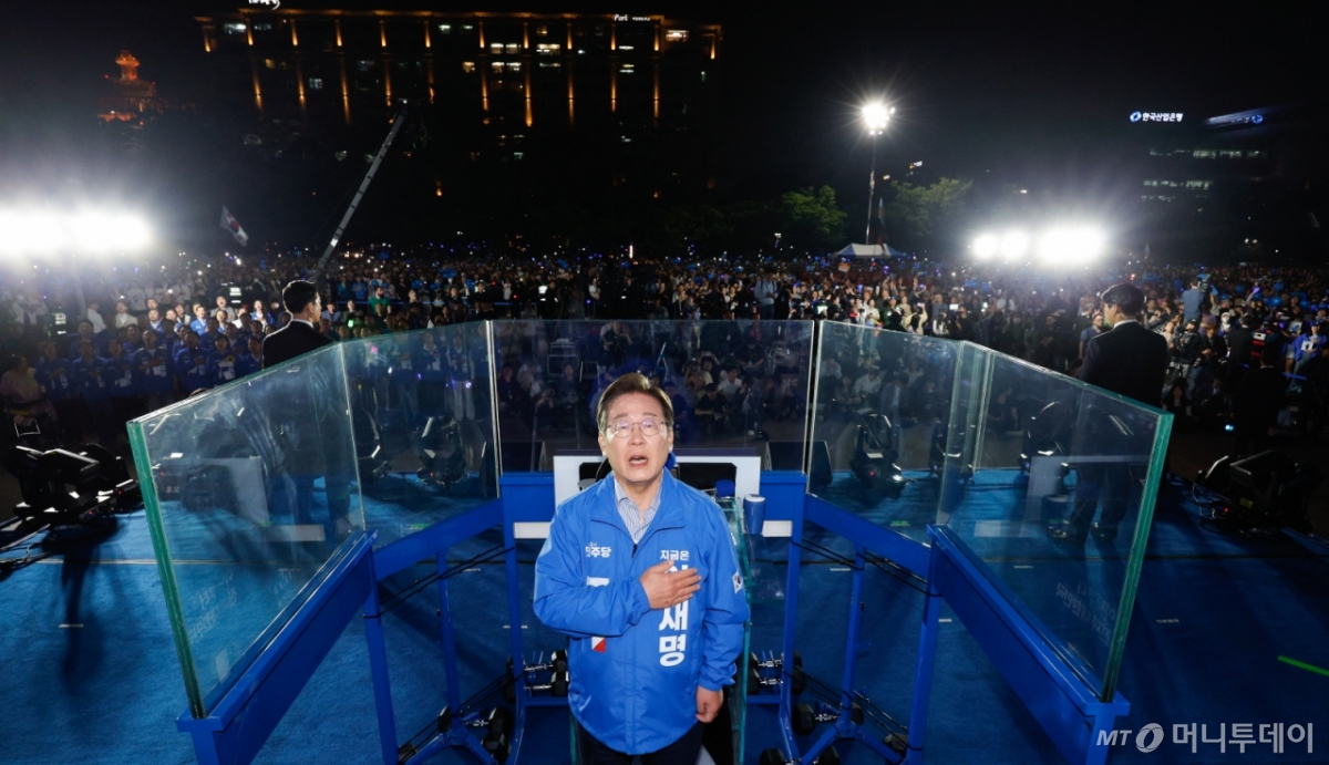 (서울=뉴스1) 안은나 기자 = 이재명 더불어민주당 대통령 후보가 제21대 대통령선거를 하루 앞둔 2일 오후 서울 영등포구 여의도공원에서 열린 마지막 집중 유세에 참석해 애국가를 부르며 국기에 대한 경례를 하고 있다. 2025.6.2/뉴스1 Copyright © 뉴스1. All rights reserved. 무단 전재 및 재배포, AI학습 이용 금지. /사진=(서울=뉴스1) 안은나 기자