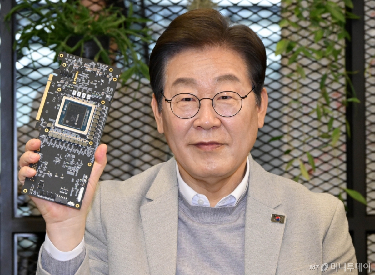 이재명 대통령이 지난 4월 14일 예비후보 시절 서울 강남구 퓨리오사AI에서 퓨리오사AI NPU칩을 들어보이고 있다./사진=공동취재단