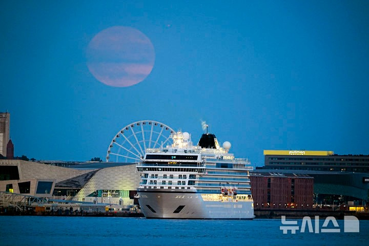 [리버풀=AP/뉴시스] 10일(현지 시간) 영국 머지사이드 리버풀 하늘에 스트로베리 문이 떠오르고 있다. 스트로베리 문은 북미 원주들이 딸기를 수확하는 시기인 6월에 뜨는 달을 의미한다. 2025.06.11.