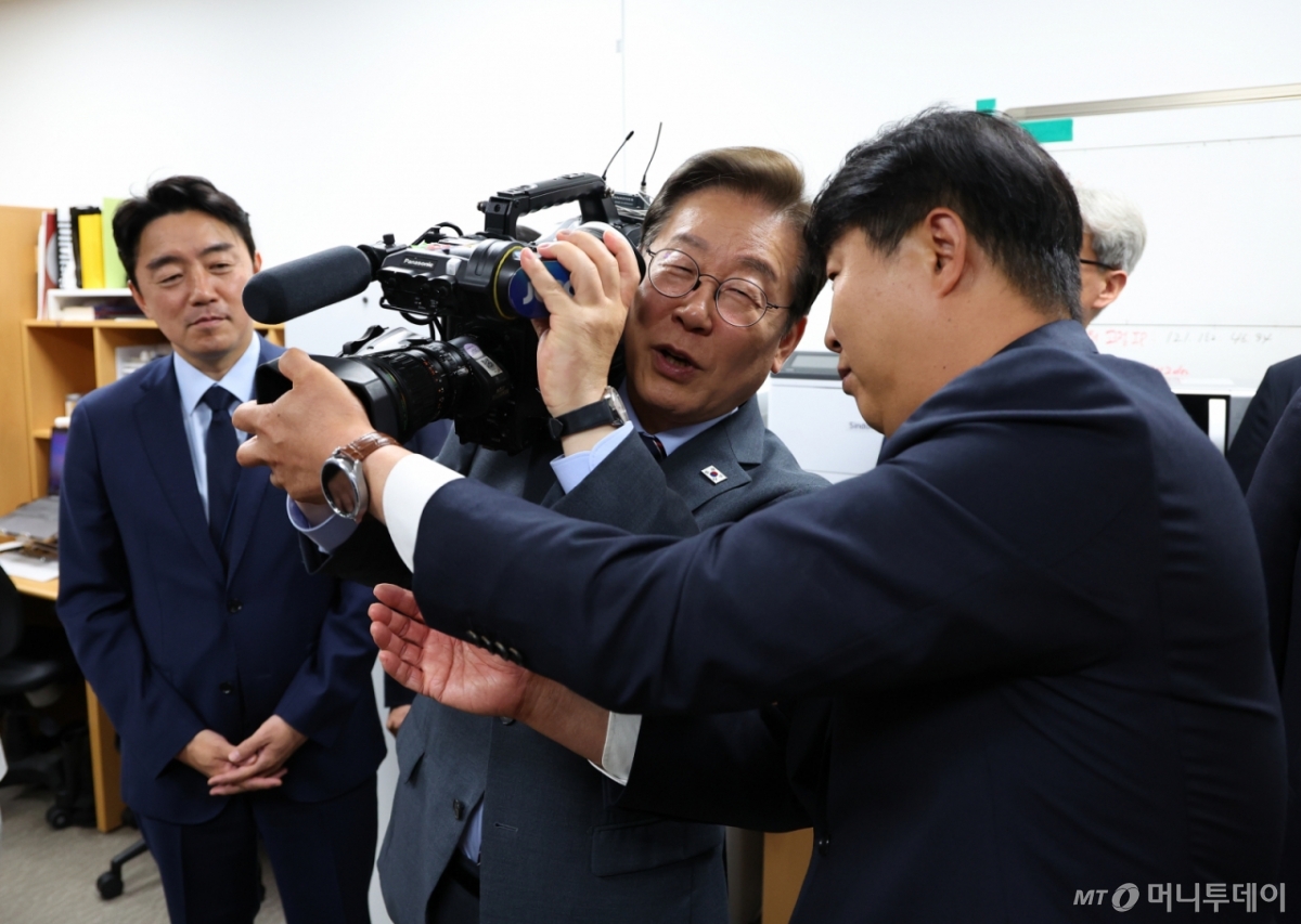 [서울=뉴시스] 최진석 기자 = 이재명 대통령이 12일 서울 용산 대통령실 영상기자실을 방문해 영상카메라를 들어 보이고 있다. 2025.06.12. myjs@newsis.com /사진=최진석
