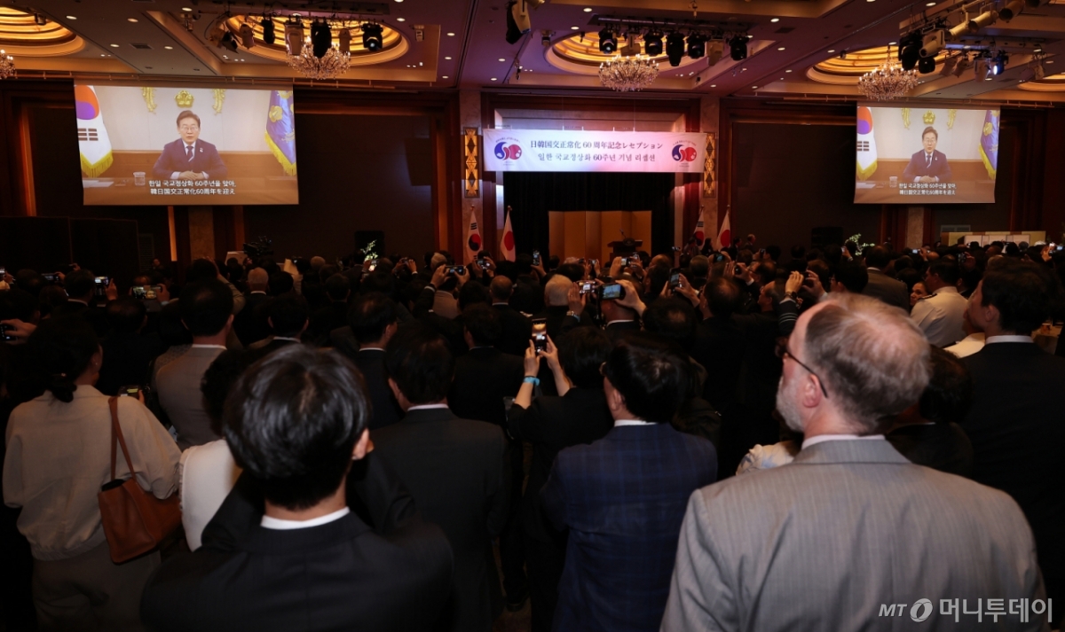 16일 서울 중구 롯데호텔에서 열린 한일 국교정상화 60주년 기념 리셉션에서 이재명 대통령의 축사 영상이 나오고 있다. / 사진=뉴스1