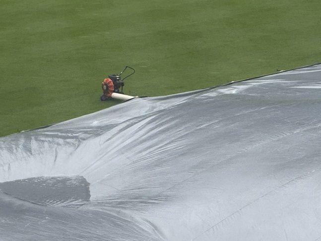 창원NC파크에 설치된 방수포의 물을 털어내고 있다. /사진=양정웅 기자