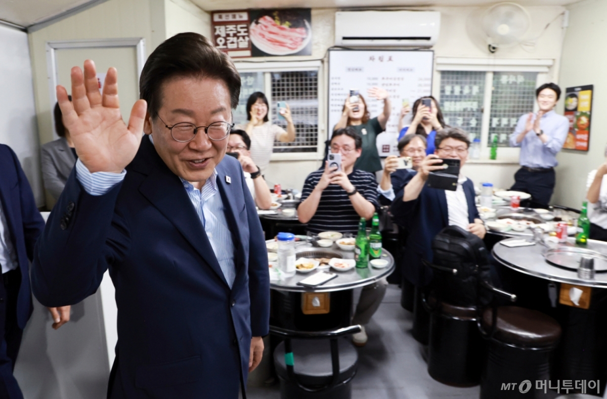 [서울=뉴시스] 최동준 기자 = 이재명 대통령이 11일 서울 종로구 한 식당에 도착해 시민들에게 인사하고 있다.  이 대통령은 SNS에 식사 계획을 알리며 "이처럼 어려운 시기에 21일부터 시행되는 민생회복 소비쿠폰 정책이 내수 진작과 지역 경제 활성화에 활력을 불어넣길 기대한다"고 밝혔다. (대통령실통신사진기자단) 2025.07.11. photocdj@newsis.com /사진=최동준