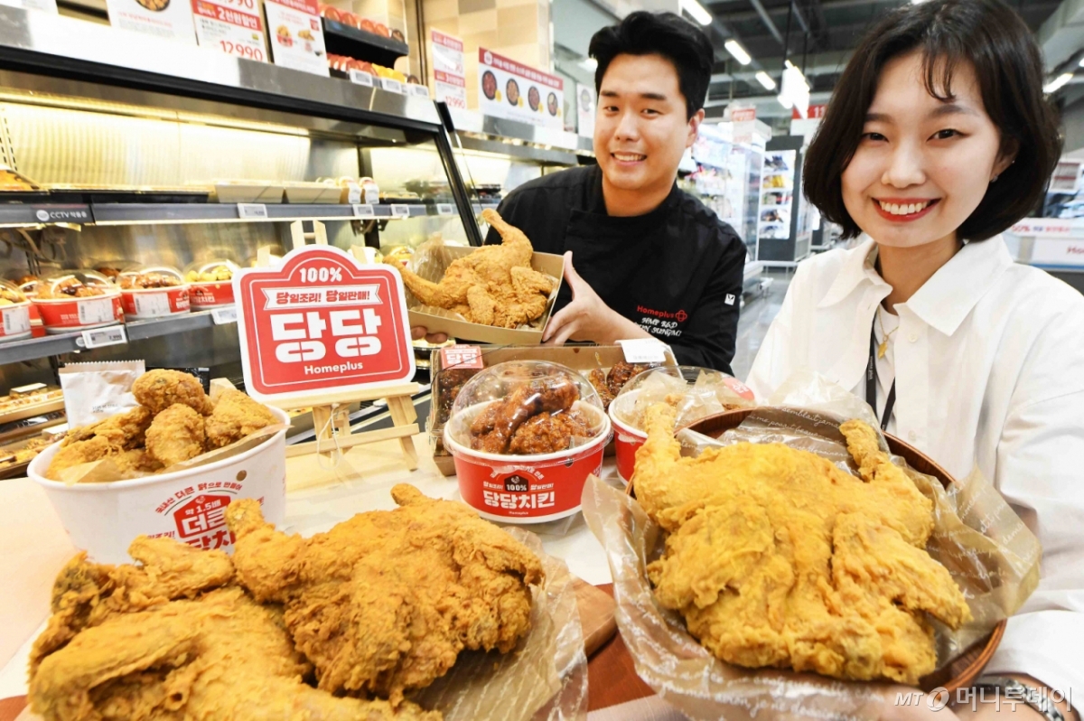 윤성민 홈플러스 델리사업팀 핫델리 담당 개발자(왼쪽)와 김태경 바이어가 29일 서울 '홈플러스 메가 푸드 마켓 라이브' 강서점에서 당당치킨 3주년을 기념해 '당당 3990옛날통닭'을 선보이고 있다. 홈플러스는 당당치킨 3주년을 맞아 다음달 3일부터 6일까지 '당당 3990옛날통닭'을 1마리 3990원에 판매한다. (홈플러스 제공. 재판매 및 DB 금지) 2025.6.29/뉴스1