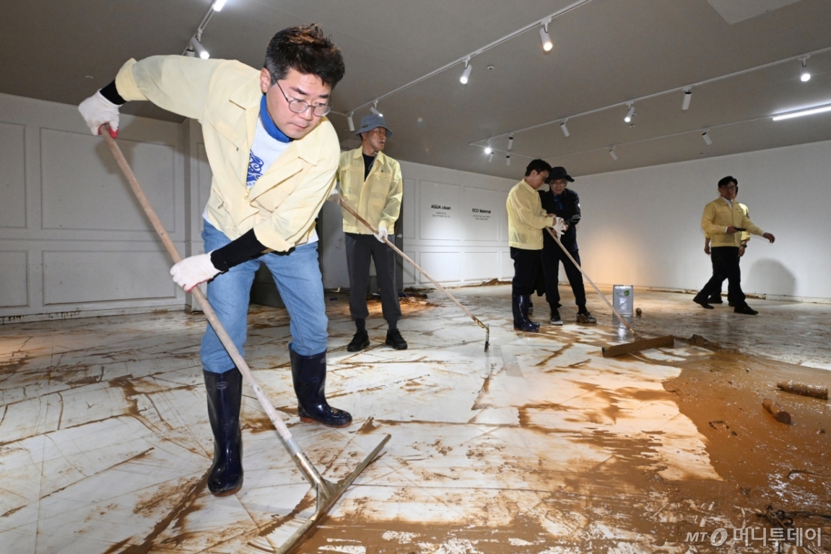 [광주=뉴시스] 이영주 기자 = 박찬대 더불어민주당 당대표 후보가 21일 오후 광주 서구 한 수해 피해 가구백화점을 찾아 수해복구 봉사활동에 참여하며 밀대를 이용해 흙탕물을 정리하고 있다. 광주에는 지난 17일 하루에만 426.4㎜의 비가 내렸다. 1939년 기상관측 이후 역대 최고 일 강수량으로 종전 기록인 1989년 7월25일 335.6㎜와 비교해 90.8㎜나 많았다. 2025.07.21. leeyyj2578@newsis.com /사진=