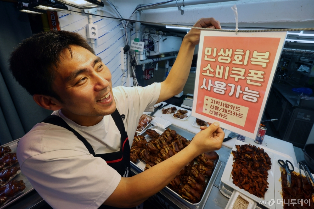 (서울=뉴스1) 황기선 기자 = 민생회복 소비쿠폰 1차 신청 첫 날인 21일 서울의 한 족발전문점에서 상인이 쿠폰 사용 관련 안내문을 붙이고 있다. 2025.7.21/뉴스1  Copyright © 뉴스1. All rights reserved. 무단 전재 및 재배포,  AI학습 이용 금지. /사진=(서울=뉴스1) 황기선 기자