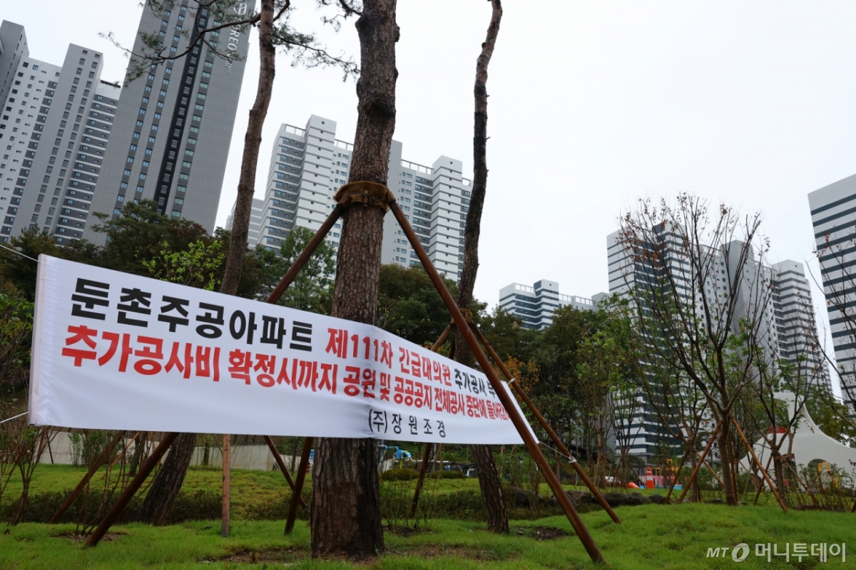 [서울=뉴시스] 황준선 기자 = 22일 서울 강동구 올림픽파크포레온 단지에 공사중단을 알리는 현수막이 게시돼 있다.   입주를 한 달여 앞둔 서울 강동구 둔촌주공 재건축(올림픽파크포레온)은 재건축 현장 주변 도로와 조경 등 기반시설을 담당 시공사들의 추가 공사비 요구를 조합이 거부하며 지난 19일부터 공사가 중단됐다.  2024.10.22. hwang@newsis.com /사진=황준선