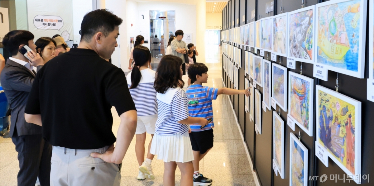 지난 25일 '50년 후의 바다상상하기 그림공모전' 시상식이 열린 부산 국립해양박물관 대강당 앞에 마련된 공모전 수상작 전시관에서 관람객들이 작품들을 둘러보고 있다. /사진=김창현 기자 chmt@