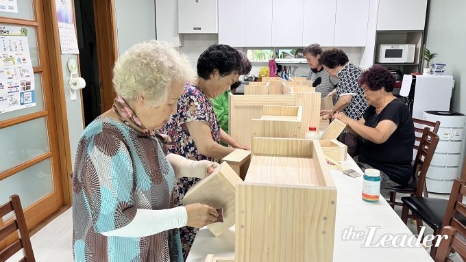 ▲화성2리 경로당에서 ‘찾아가는 온마을돌봄센터’ 목공예 수업이 진행됐다. 열심히 사포질을 하고 있는 어르신들/사진=신재은 기자